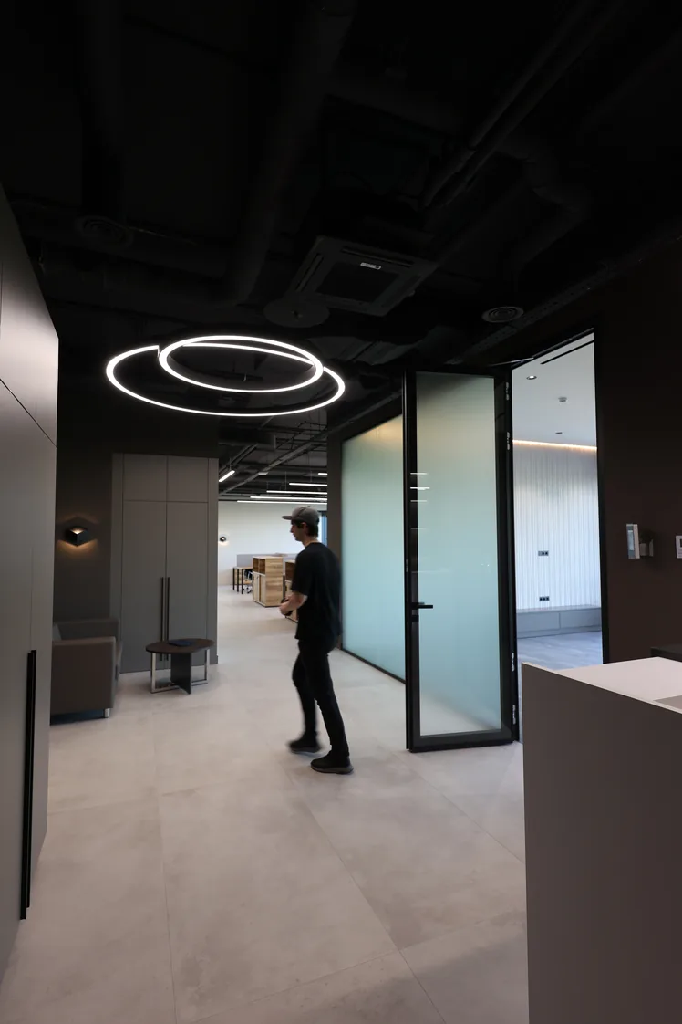 Проход офиса 230 м² с зоной ожидания, стеклянными перегородками и кольцевыми светильниками